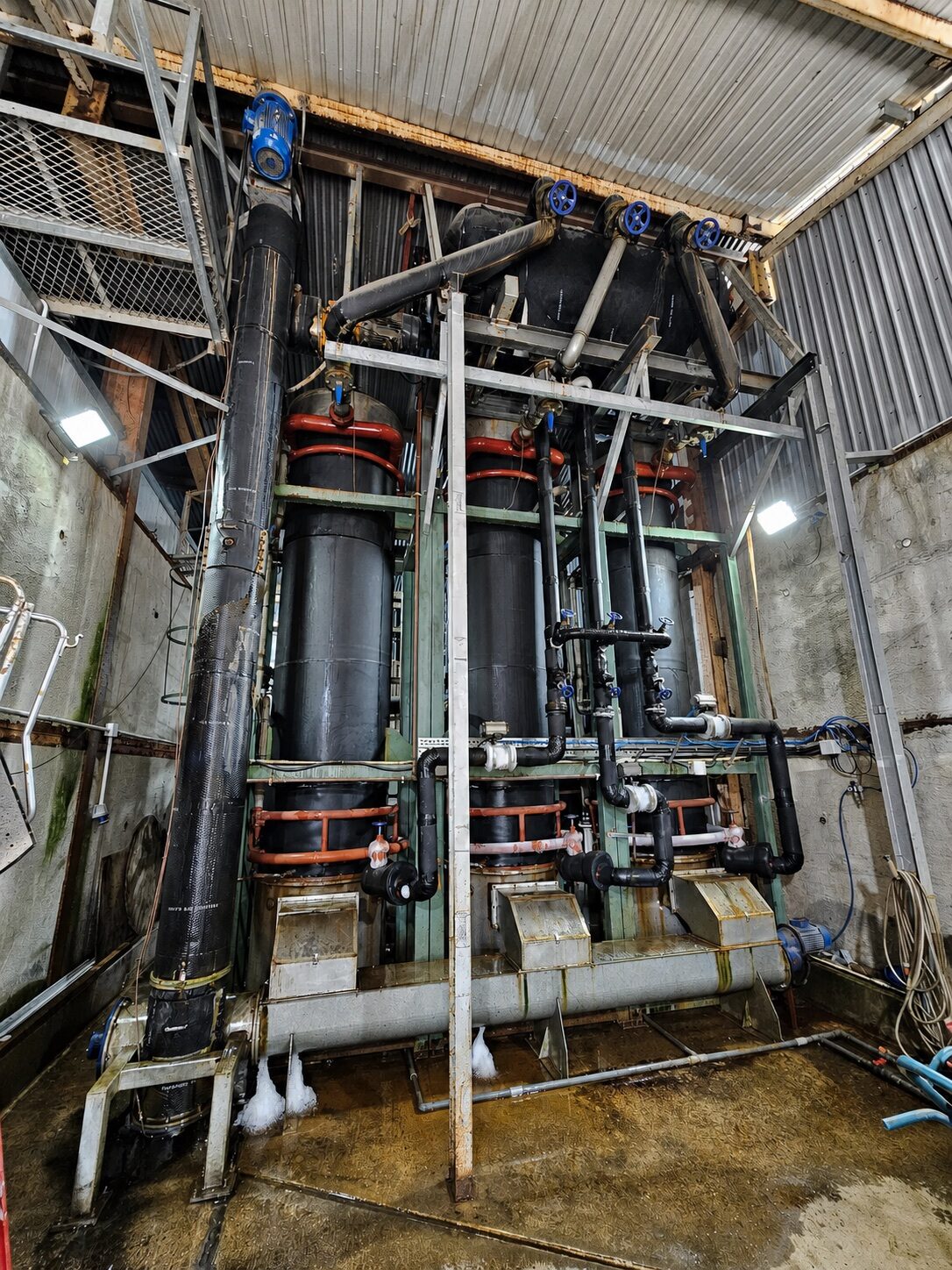 Three vertical tube-ice production units with connected insulated pipework in Sheung Shui