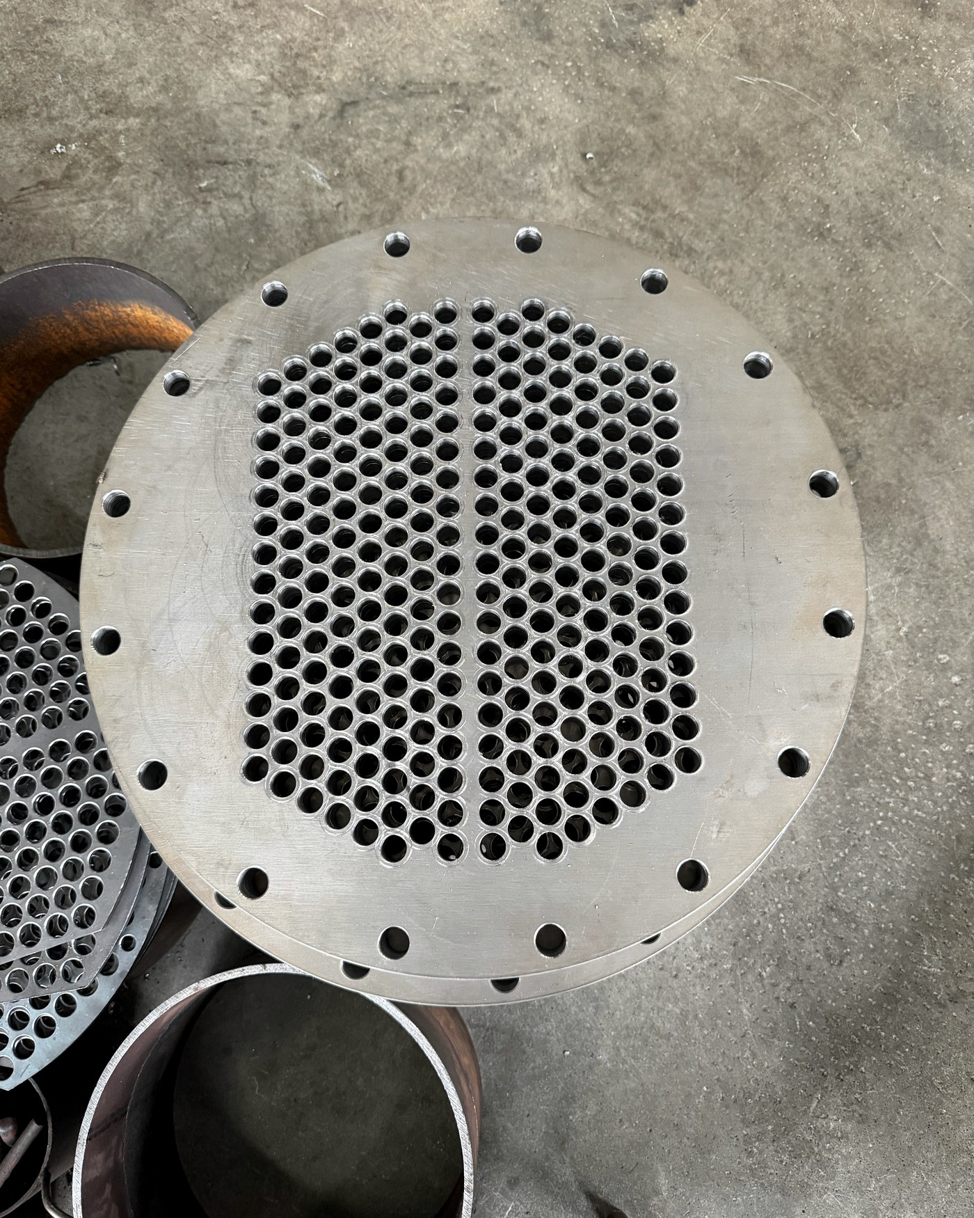 Heat-exchanger tube sheet with its circular hole pattern visible.