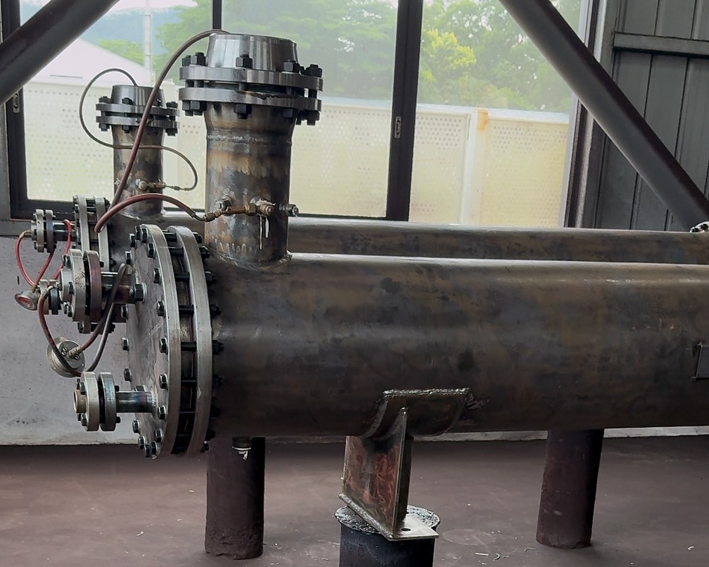 Pressure-bearing steel equipment connected to a pressure-test setup on the factory floor.