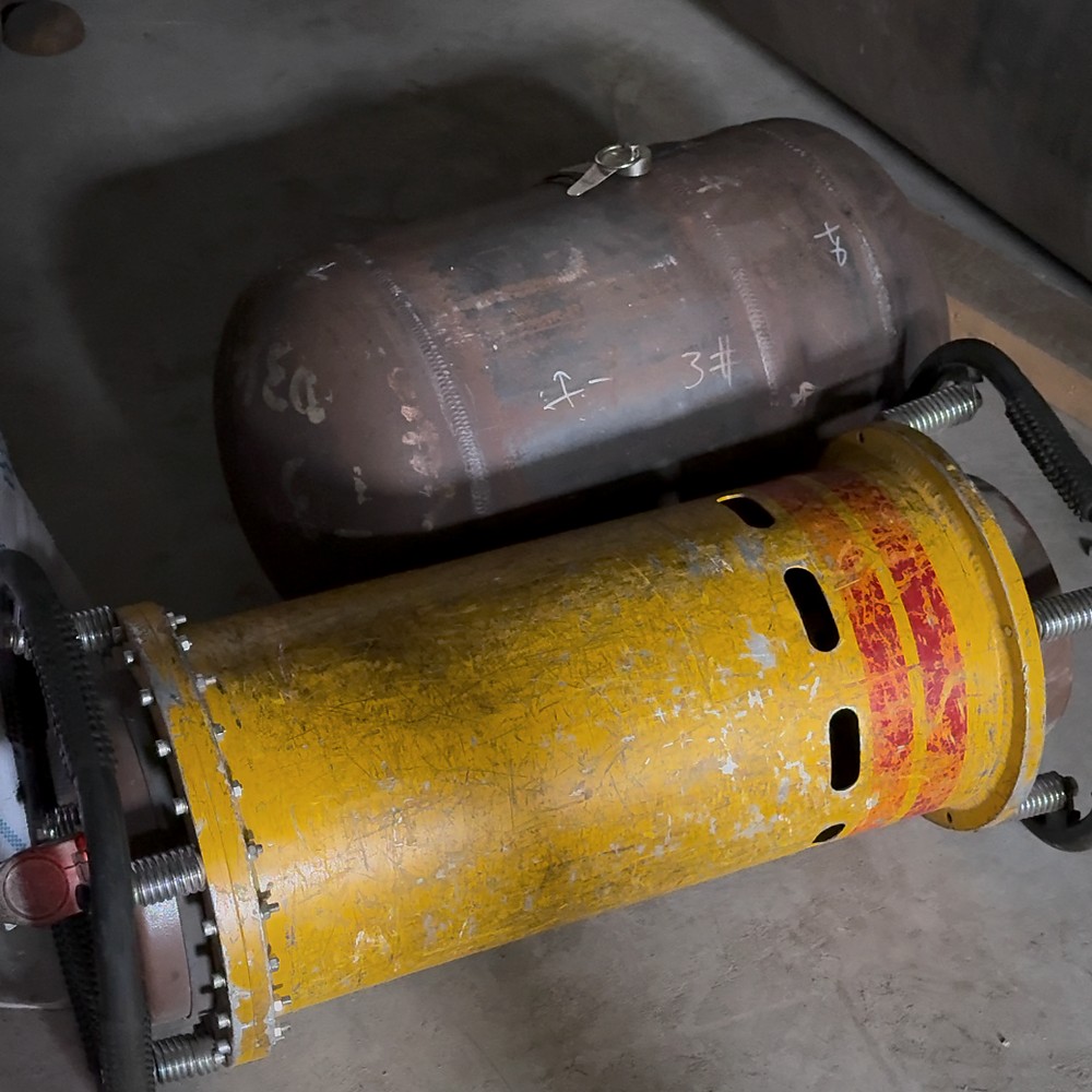 Portable X-ray examination unit positioned beside a welded steel pressure component.